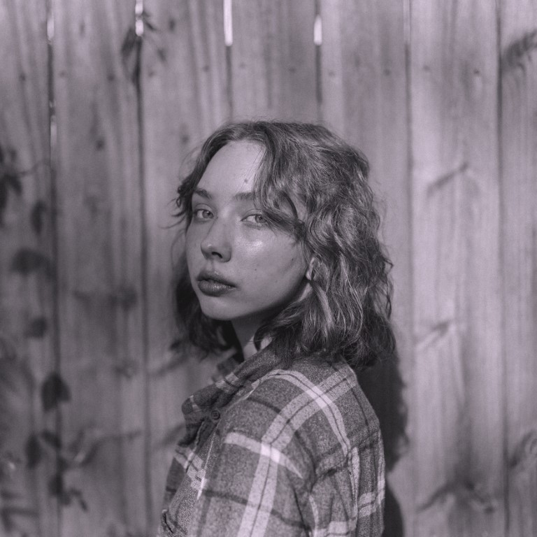 A black and white portrait of me standing in front of a construction site.